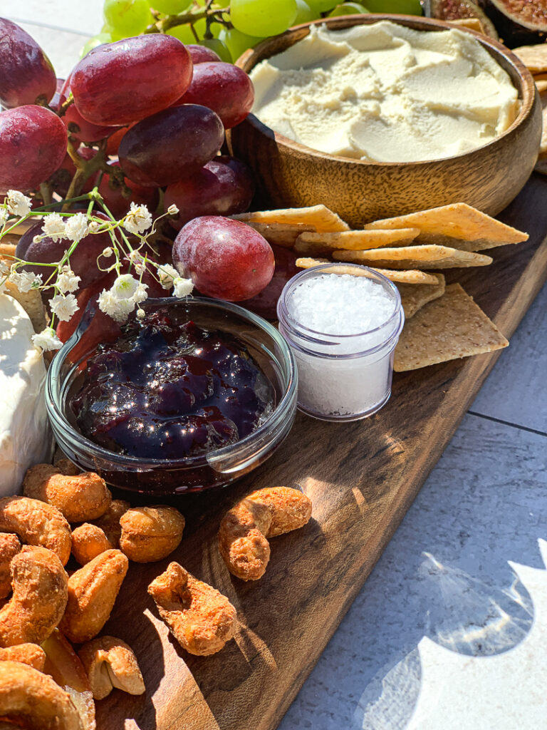 close-up of cheese board showcasing finishing sea salt and jam. 